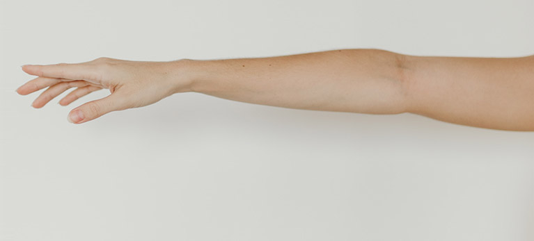 Image of an arm extended to the side with fingers straight